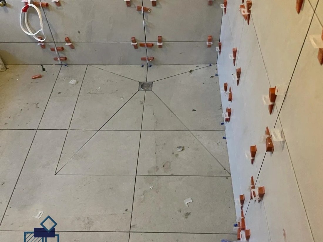 Shower floor being tiled with levelling clips