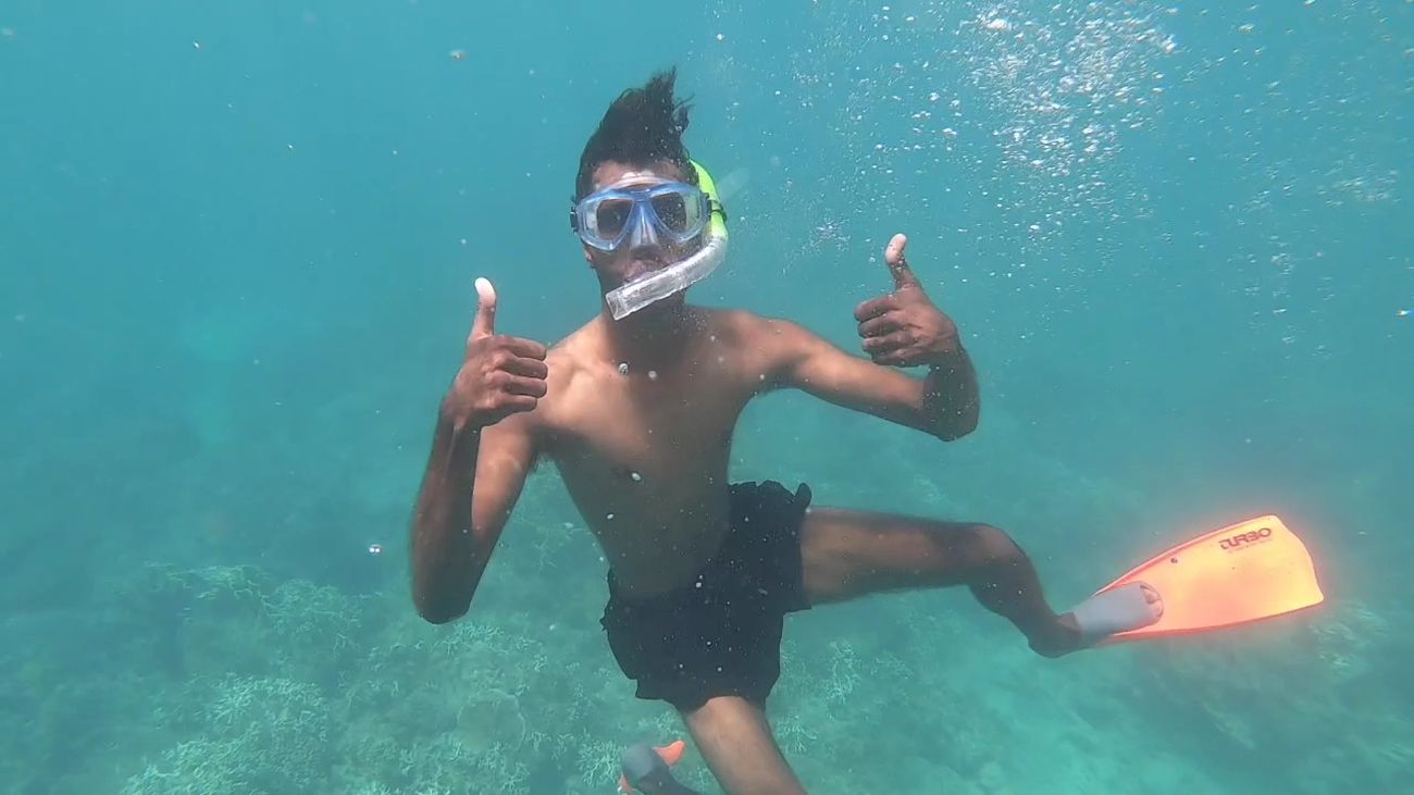 Thumbs up from a snorkeller over the coral gardens